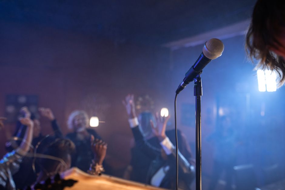 Noćni klub s plesnom publikom i mikrofonom na pozornici